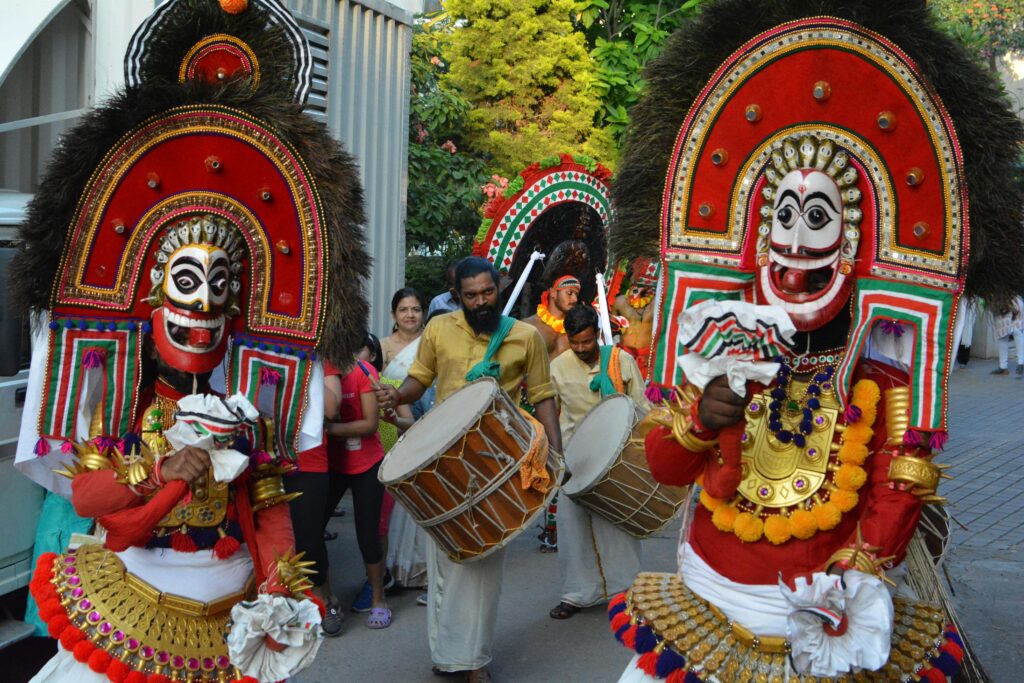A colorful street parade featuring traditional performers in Bengaluru, India.